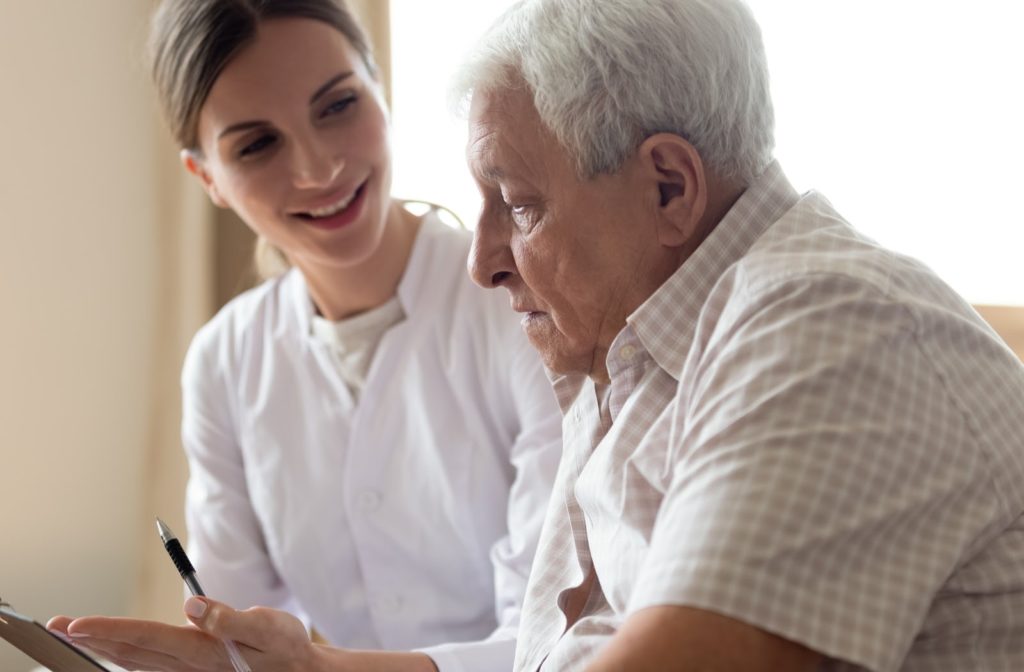 An older man being instructed on potential medicare coverage. 