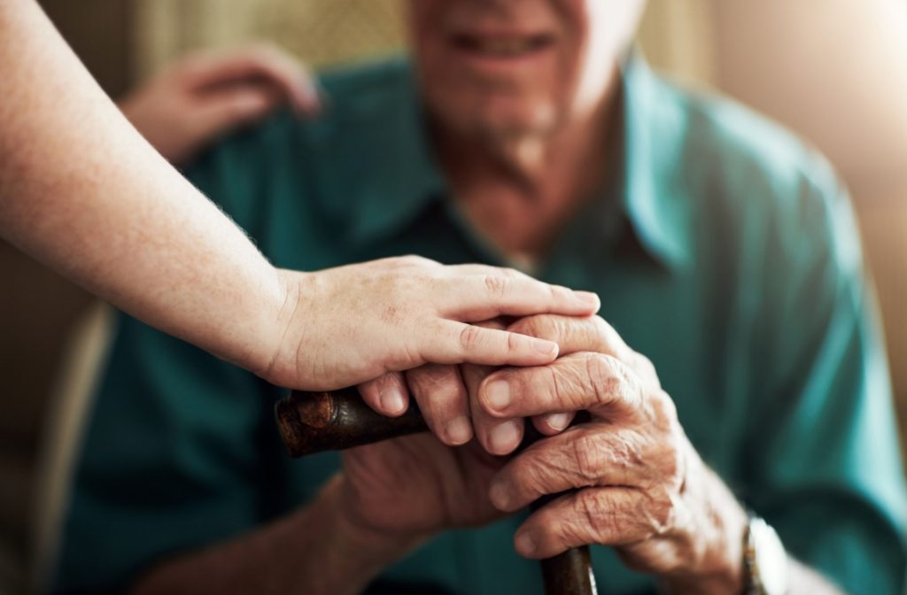 a senior living attendant helping a senior with fall prevention measures.