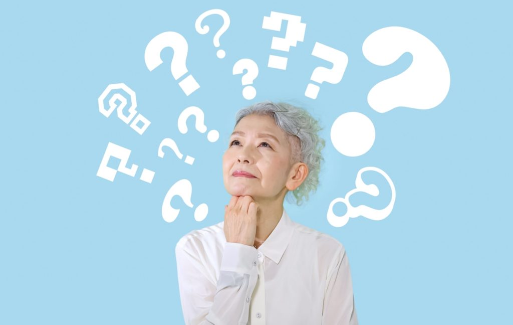 An older adult looks into the distance thoughtfully. Question marks hang above their head to show their concentration.