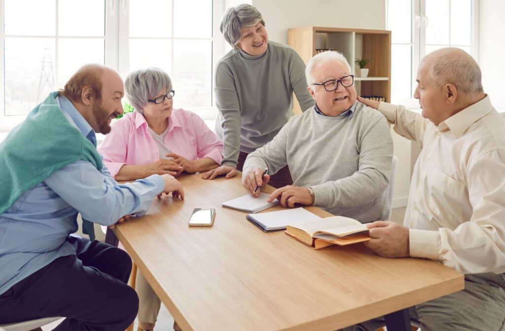 Five seniors crowd around a table, taking notes on a book they’ve recently read together, exercising their brains