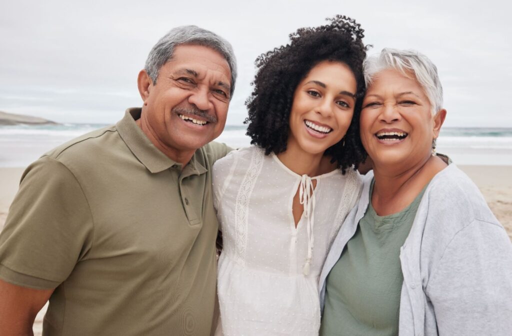 An adult child smiles with their senior parents during a get-together after their parents started living separately for care