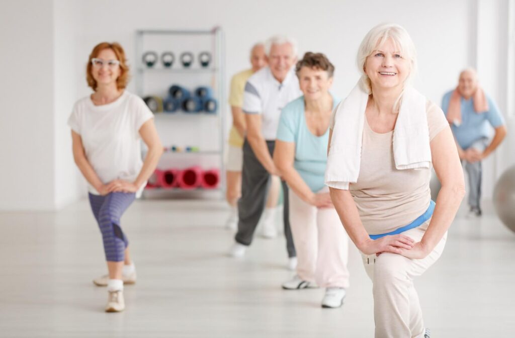 A group of seniors exercise in a fitness club in a senior living community.
